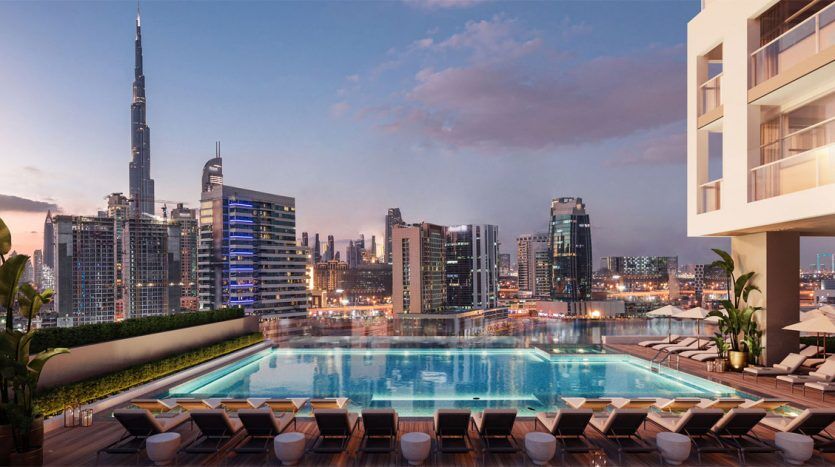 Une piscine sur le toit au crépuscule avec une vue imprenable sur les toits de la ville du 15e Northside, avec des gratte-ciel modernes, dont une tour proéminente. Des chaises longues au bord de la piscine bordent la terrasse sous un doux