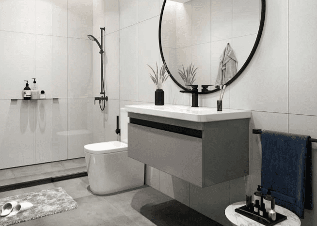Une salle de bain moderne dotée d'un miroir circulaire, d'un lavabo rectangulaire, de toilettes murales et d'une douche à l'italienne. Les couleurs neutres dominent le 15ème espace nord avec des éléments décoratifs comme des plantes et des serviettes.