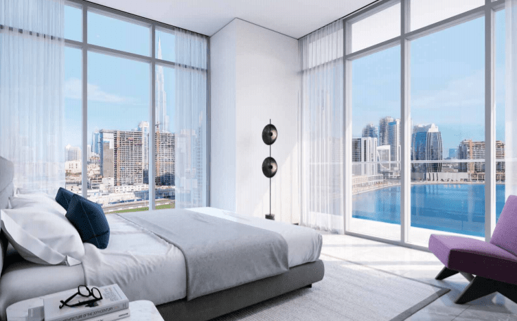 Une chambre moderne et aérée avec de grandes fenêtres offrant une vue dégagée sur le paysage urbain et l'eau. La chambre dispose d'un grand lit, de rideaux blancs et d'une décoration minimaliste au 15th Northside.