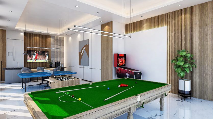 Salle de jeux spacieuse et moderne comprenant une table de billard, un baby-foot, un espace télévision et un coin détente avec une grande plante en pot, orné de murs lambrissés et d'un éclairage contemporain.