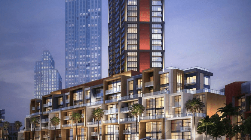 Vue lumineuse en soirée d'un immeuble résidentiel moderne en bord de mer sur la péninsule de Dubaï avec un yacht amarré à proximité. On voit des gens se promener et converser au premier plan, mettant en valeur la scène urbaine.