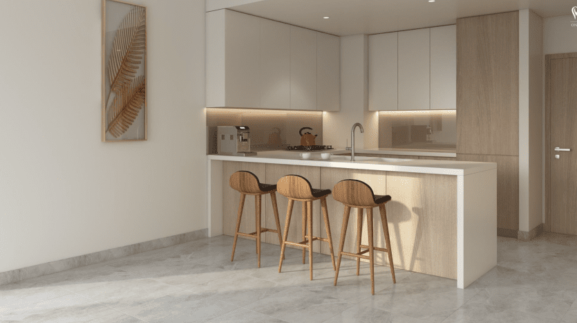 Une cuisine moderne avec des armoires beiges, un îlot blanc avec des tabourets en bois et une décoration contemporaine inspirée du Peninsula Dubai. L'espace est bien éclairé par la lumière naturelle, qui se reflète sur les sols en marbre gris.