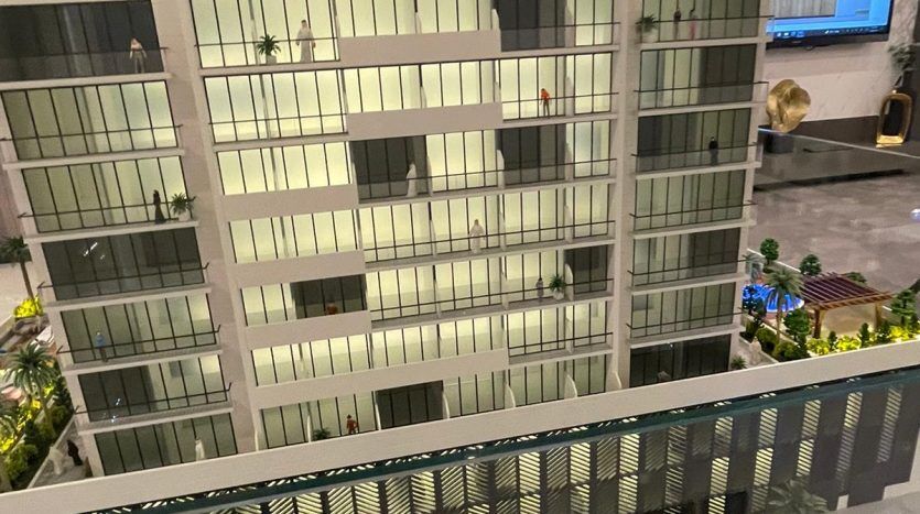 Une maquette de « Prime Residency 3 », un bâtiment moderne avec des extérieurs détaillés, y compris des plantes de balcon. Le modèle présente une rue à petite échelle avec des voitures et des lampadaires, exposée à l'intérieur.
