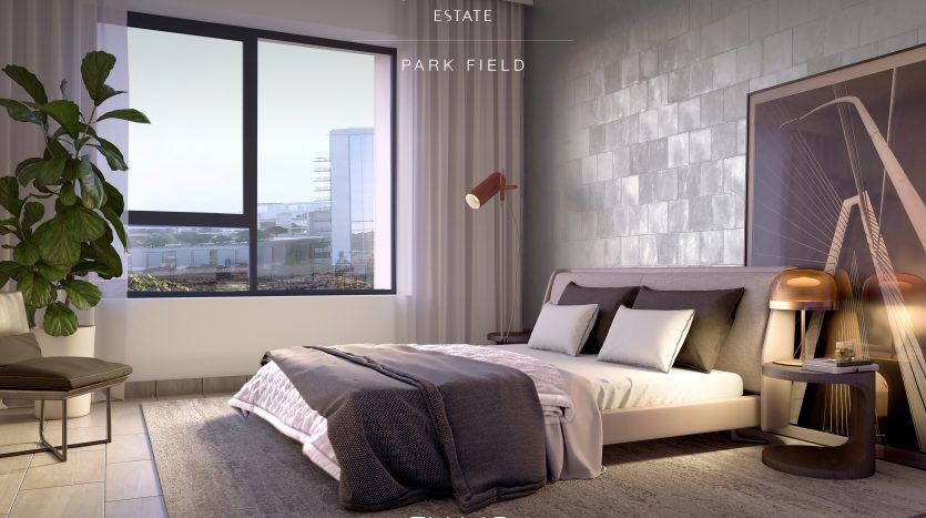Intérieur de chambre moderne dans des tons neutres avec lumière naturelle entrant par une grande fenêtre, comprenant un lit, des tables de chevet, un banc et une vue sur les bâtiments de la ville de Dubaï. La pièce comprend des plantes décoratives et