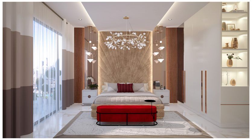 Une chambre moderne et luxueuse dans une villa à Dubaï avec un grand lit doté d'une tête de lit aux tons terre, d'un pouf rouge, d'un plafonnier complexe, flanqué de rideaux transparents et opaques et de blanc