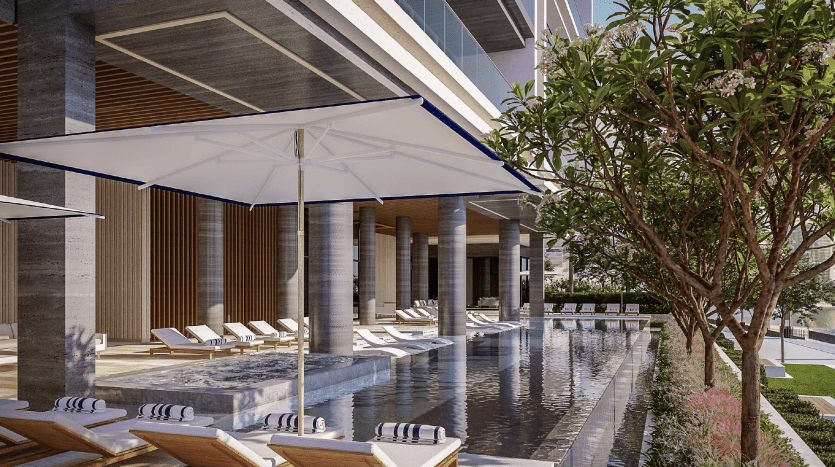 Un espace piscine extérieur luxueux à Dubaï, flanqué de colonnes modernes, doté de chaises longues au bord de la piscine sous de grands parasols blancs et d'une verdure luxuriante renforçant l'ambiance sereine.