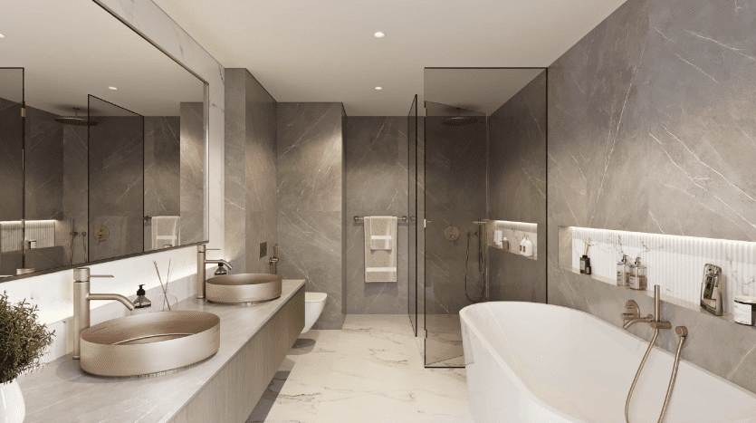 Une salle de bains moderne dans une villa de Dubaï aux murs en marbre gris comprend deux lavabos avec des miroirs ronds, une baignoire sur pied et un espace douche séparé vitré.