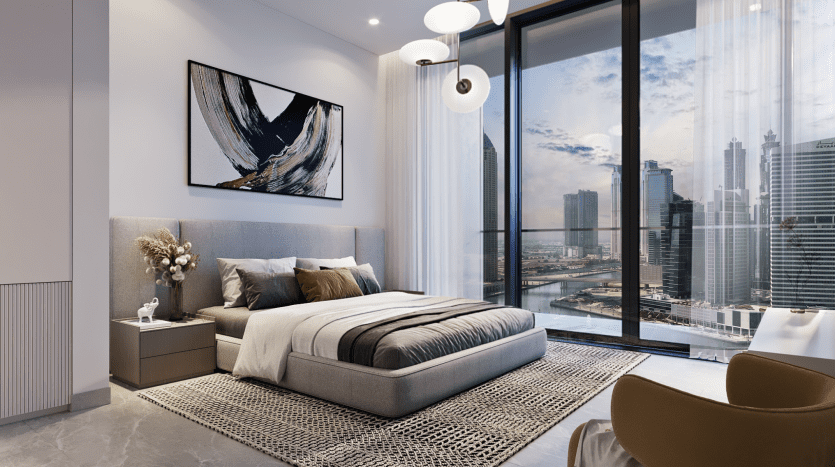 Chambre moderne avec un grand lit, des œuvres d'art abstraites au mur et une vue panoramique sur les toits de Dubaï à travers des baies vitrées. La chambre présente des tons neutres et des éléments de design contemporain.
