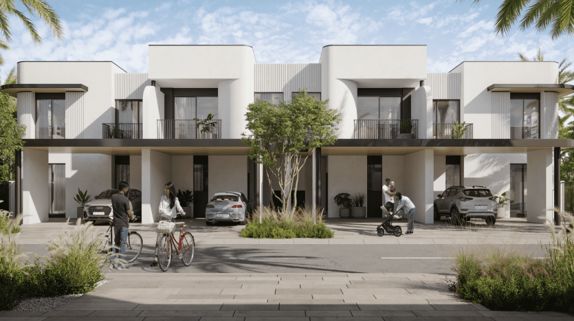 A modern residential complex with symmetrical white villas. People interact and carry out their daily activities in a communal courtyard with parked cars and lush greenery.