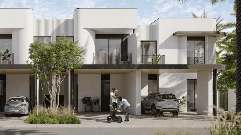 A modern residential complex in Dubai featuring two-storey white buildings with elegant balconies. A man pushes a stroller and interacts with a child in front of the houses, with cars parked nearby.