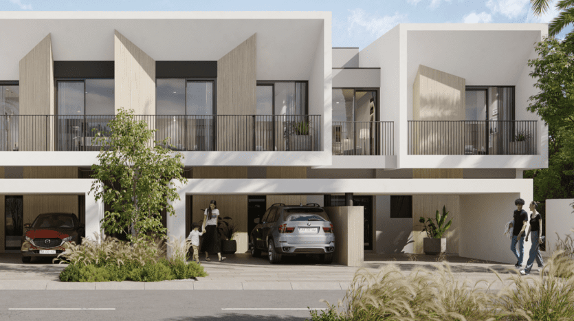 Modern residential building in Dubai with an elegant design comprising several units, balconies, carports with vehicles and people walking and chatting outside. Lush greenery reinforces the tranquil suburban ambience.