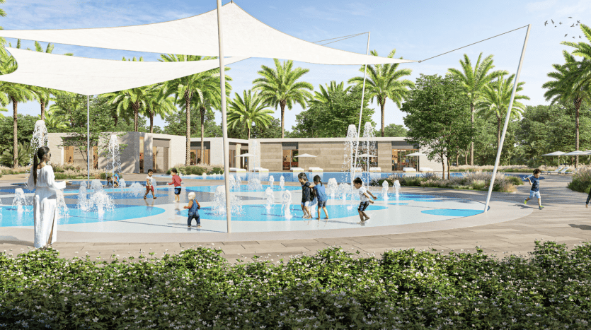 A vibrant outdoor scene showing children playing in a paddling pool under large white parasols. Adults look on nearby, amid lush greenery and palm trees under a clear blue sky, reminiscent of the luxurious villa.