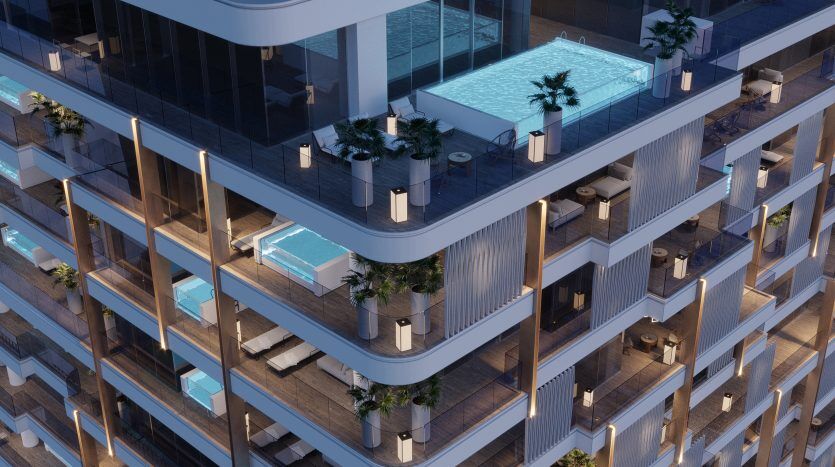 Vue aérienne d'un immeuble moderne de grande hauteur à Dubaï au crépuscule, doté de balcons avec parquet et d'une piscine éclairée sur le toit entourée de plantes.