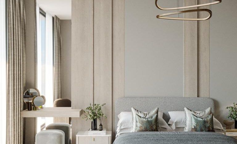 Une chambre moderne et minimaliste dans un appartement de Dubaï avec une palette de couleurs neutres, comprenant un grand lit avec une literie grise, un plafonnier rond, un bureau en bois et de grandes fenêtres avec des rideaux.