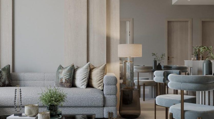 Un salon élégant dans une villa de Dubaï comprenant un canapé sectionnel gris avec des oreillers, des colonnes en bois clair, une table basse ronde en verre et un tapis bleu-gris. Des chaises élégantes et un éclairage contemporain complètent l'espace