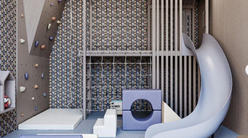 Une salle de jeux moderne pour enfants dans une villa de Dubaï comprenant un mur d'escalade, un toboggan, une piscine à balles, divers blocs de jeu et un coin lecture confortable, le tout décoré dans des tons froids et un design contemporain.