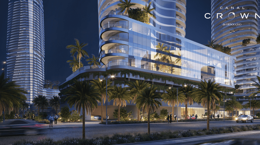 Une scène urbaine futuriste de nuit présente un gratte-ciel moderne aux fenêtres illuminées et à l'architecture particulière, rappelant l'élégance du Canal Crown de Damac. En contrebas, des palmiers bordent les rues, créant une atmosphère élégante et contemporaine.