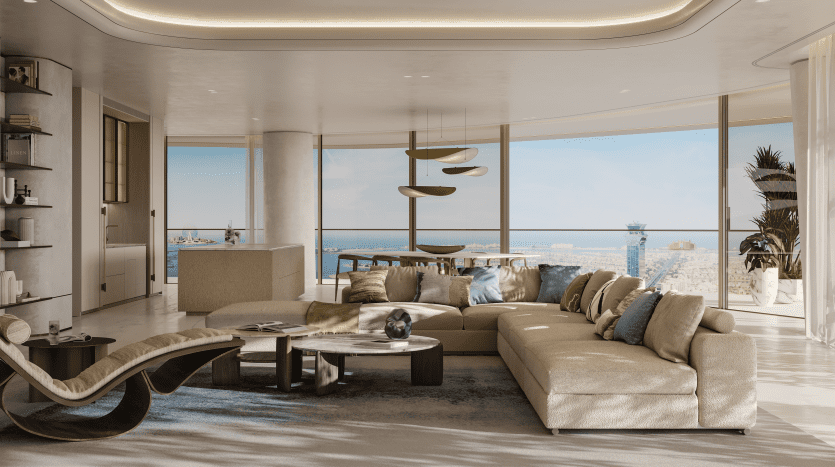 Un salon luxueux dans un appartement de Dubaï avec de grandes fenêtres offrant une vue sur l'océan. La pièce présente un design moderne, avec un canapé incurvé, des chaises élégantes et des luminaires suspendus distinctifs.