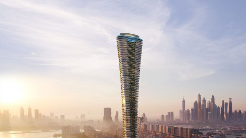 Un gratte-ciel torsadé futuriste illuminé par le soleil levant, surplombant un paysage urbain et un littoral de Dubaï, sous un ciel rose et bleu tendre.