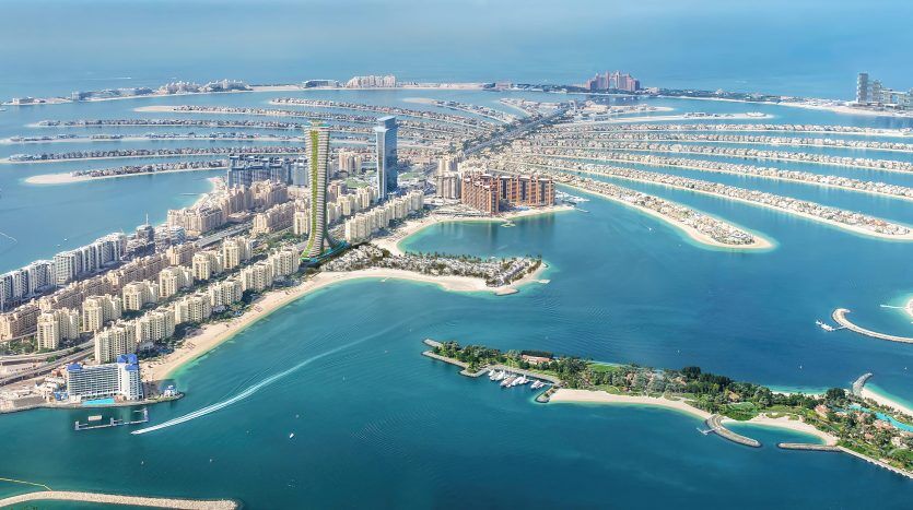 Vue panoramique aérienne de Palm Jumeirah, un archipel artificiel de Dubaï, en forme de palmier avec des villas résidentielles le long des frondes et un croissant qui l'entoure.