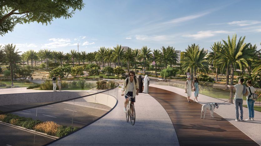 Un couple fait du vélo ensemble le long d'un sentier sinueux près de leur villa à Dubaï, entouré d'une verdure luxuriante et de palmiers, avec des gens marchant et profitant d'une journée ensoleillée.