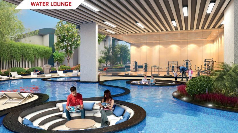 Un luxueux salon aquatique où les gens se détendent dans des sièges circulaires en contrebas entourés de jeux d'eau. En arrière-plan, une salle de sport avec des gens qui s'entraînent est visible à travers de grandes fenêtres, mettant en valeur l'immobilier exclusif.