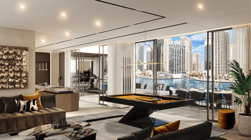 Intérieur luxueux d'un appartement en hauteur comprenant un coin salon avec des canapés et une table de billard, menant à un balcon donnant sur le bord de la rivière et les gratte-ciel de Dubaï.