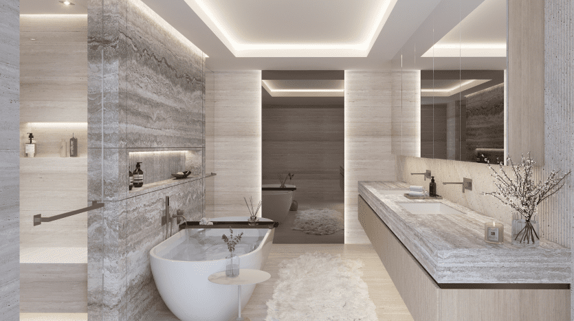 Salle de bain luxueuse dans une villa de Dubaï comprenant une baignoire îlot, une double vasque avec miroirs, des murs en pierre texturée et un éclairage d'ambiance. Un tapis blanc moelleux et un vase avec des fleurs ajoutent des touches élégantes.