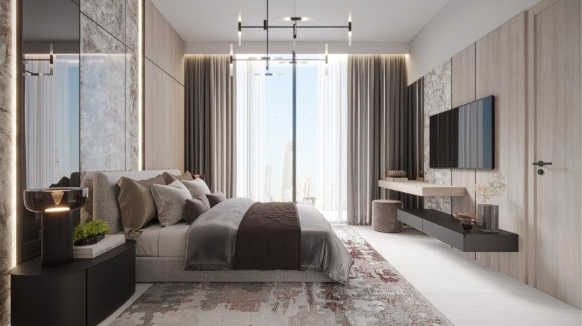 Intérieur de chambre moderne comprenant un grand lit avec une literie grise, des tables de chevet, une télévision murale et des baies vitrées offrant une vue sur le paysage urbain de Dubaï. La pièce allie tons boisés et éclairage tamisé.