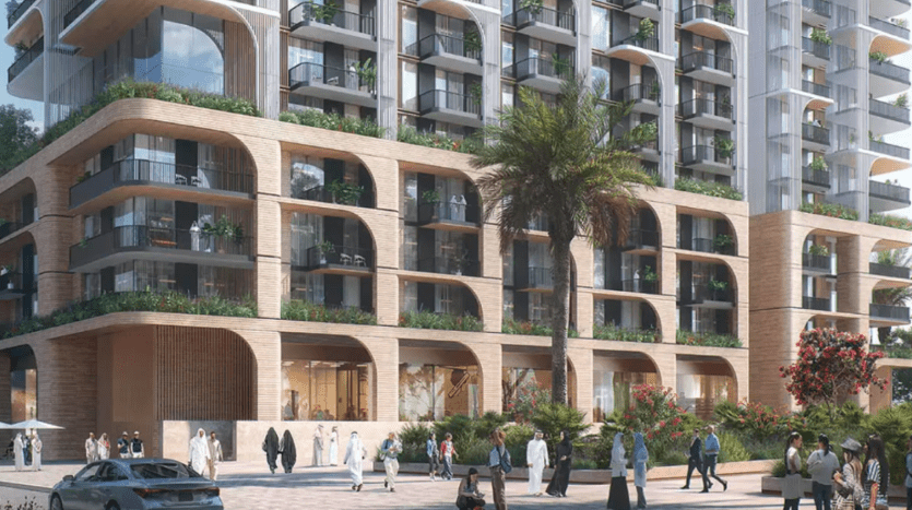 Un immeuble résidentiel moderne avec une façade à usage mixte dotée de grands balcons cintrés et d'une verdure luxuriante. Les gens marchent le long de la zone piétonne devant le bâtiment, qui comprend des palmiers et des plantes à fleurs. Le bâtiment présente une conception architecturale contemporaine.
