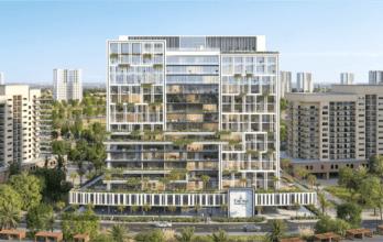 Fairway Residences Prescott est un immeuble d'appartements moderne à plusieurs étages avec des sections de verdure sur différents étages. D'autres bâtiments similaires l'entourent et de grands gratte-ciel sont visibles en arrière-plan. Les palmiers et l'aménagement paysager embellissent l'espace devant le bâtiment.