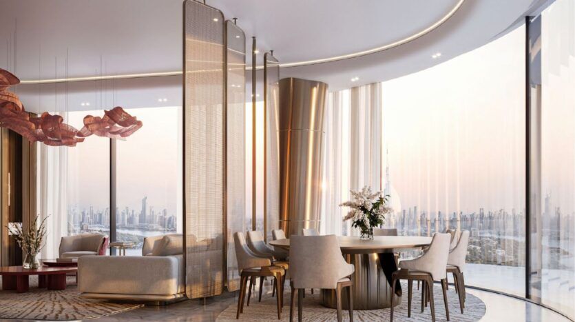 Un luxueux salon et salle à manger moderne dans le Binghatti Skyblade avec des fenêtres incurvées allant du sol au plafond, des meubles élégants, des touches d'or et une vue sur la ville au coucher du soleil. Des chaises en peluche, une table ronde et un éclairage décoratif créent une ambiance sophistiquée.