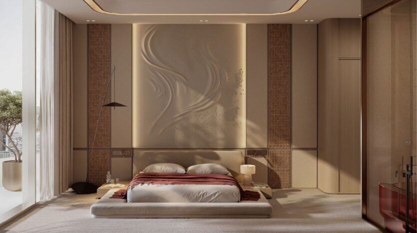La chambre à coucher moderne et minimaliste du Binghatti Skyblade est dotée d'un lit bas à plate-forme, d'une literie blanche avec une couverture bordeaux, d'un art mural texturé, d'un éclairage doux, de fenêtres allant du sol au plafond et d'un arbre en pot sur le balcon.