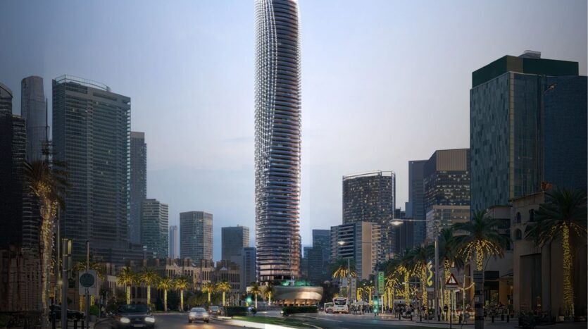 Grand gratte-ciel moderne au design incurvé unique, le Binghatti Skyblade se dresse bien en vue parmi d'autres gratte-ciel dans un paysage urbain, avec des palmiers et des lampadaires bordant une rue animée à la tombée de la nuit.