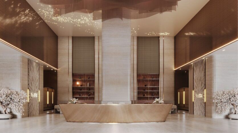 Le luxueux hall d'entrée de l'hôtel, avec sa grande réception centrale, ses élégants murs de marbre beige et ses éclairages décoratifs, donne le ton au Binghatti Skyblade. Des étagères modernes et des arrangements floraux de part et d'autre créent une atmosphère spacieuse et sophistiquée.
