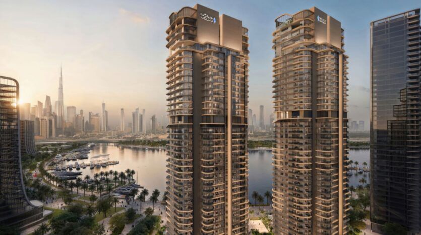 Deux tours modernes portant des panneaux "Creek Waters" mettent en valeur l'art architectural en surplombant un port de plaisance et une promenade bordée de palmiers, avec l'horizon de la ville et la Burj Khalifa visibles en arrière-plan au coucher du soleil.