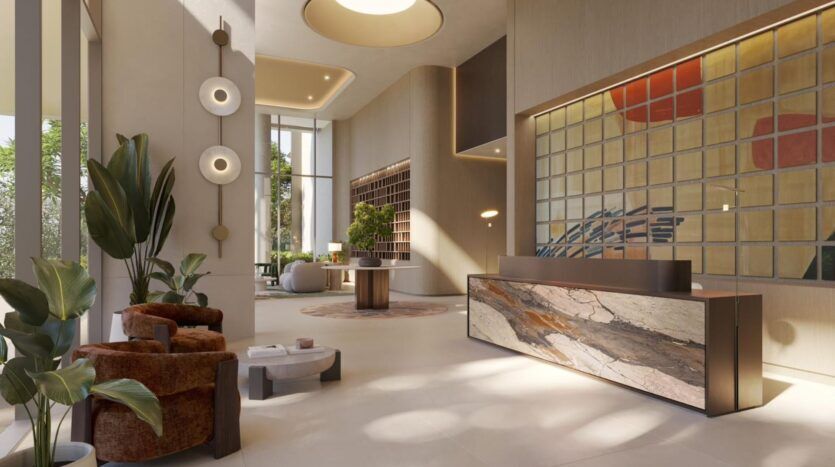Un hall moderne avec de hauts plafonds, de grandes fenêtres et un décor contemporain. Les fauteuils bruns, les plantes en pot, le bureau de réception en marbre, les œuvres d'art murales et la lumière naturelle qui remplit l'espace sont autant d'éléments artistiques.