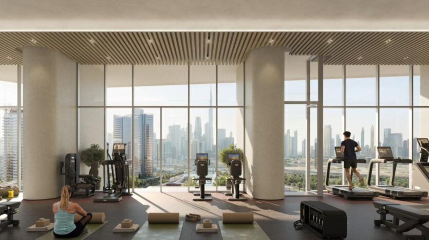 Une salle de sport moderne avec de grandes fenêtres donnant sur l'horizon de la ville, où l'art de la remise en forme prend vie. Les gens utilisent des tapis de course et font de l'exercice sur des tapis de yoga dans une lumière naturelle éclatante, entourés d'équipements bien rangés.