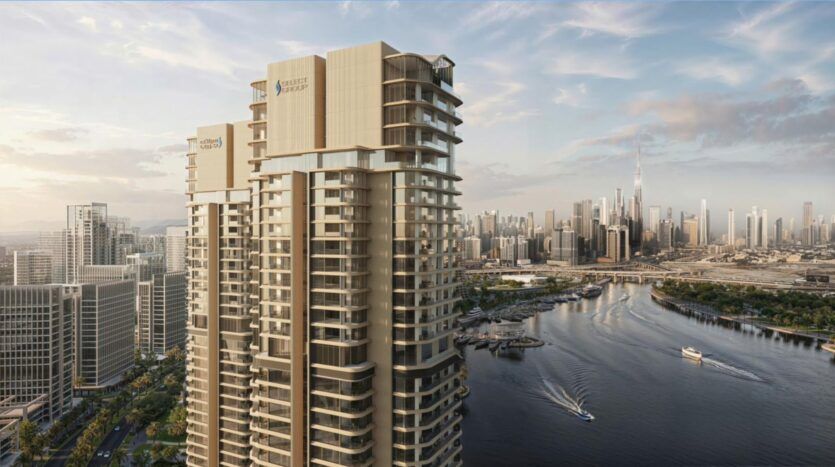 De hautes tours résidentielles mettent en valeur l'art architectural en donnant sur une rivière avec des bateaux, entourée de bâtiments urbains modernes ; une ligne d'horizon lointaine, y compris la Burj Khalifa, s'élève sous un ciel partiellement nuageux au coucher du soleil.
