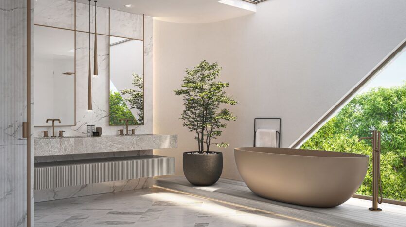 Une salle de bains moderne avec une baignoire autoportante de Bella by Passo, une grande plante en pot, un meuble-lavabo en marbre à double vasque et de grands miroirs. La lumière naturelle pénètre par une fenêtre triangulaire, mettant en valeur les arbres verts à l'extérieur.