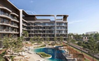 Complexe d'appartements moderne, « Mirari Lagoon by Zoya », doté de balcons incurvés donnant sur une cour paysagée agrémentée d'une piscine, de transats, de palmiers et de sentiers de promenade, sous un ciel d'un bleu limpide.