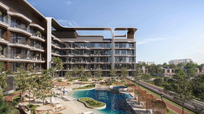 Complexe d'appartements moderne, « Mirari Lagoon by Zoya », doté de balcons incurvés donnant sur une cour paysagée agrémentée d'une piscine, de transats, de palmiers et de sentiers de promenade, sous un ciel d'un bleu limpide.