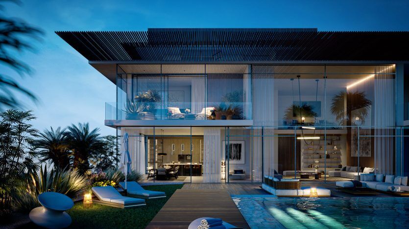 Une luxueuse maison moderne à deux étages au crépuscule, avec des intérieurs éclairés, des balcons, une piscine sereine avec des chaises longues et un feuillage de palmiers luxuriant, présentée par une agence immobilière de Dubaï.