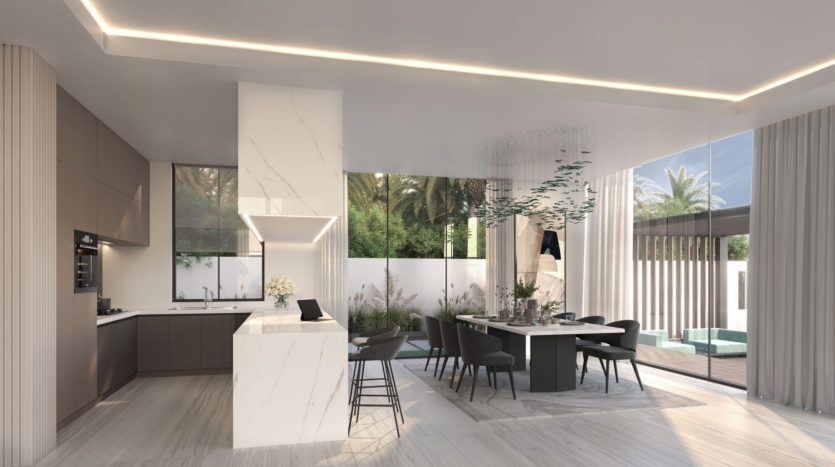 Cuisine moderne dans un appartement de Dubaï au design élégant comprenant un bar pour le petit-déjeuner, des appareils électroménagers intégrés et un coin repas avec vue sur la verdure luxuriante à travers de grandes fenêtres. Une lumière vive et naturelle améliore la propreté,