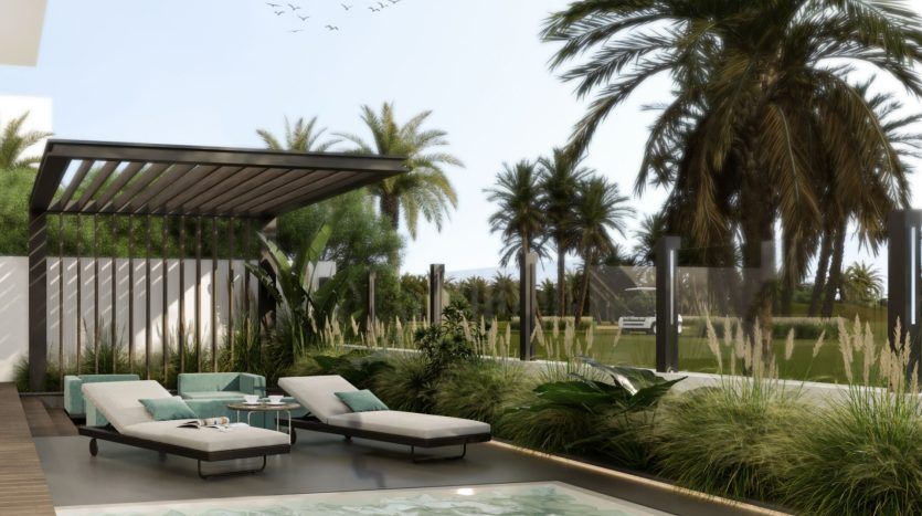 Le patio serein d'une villa à Dubaï, comprenant deux chaises longues avec des coussins bleu sarcelle sous une pergola moderne, entouré de palmiers et d'herbes luxuriantes, avec des oiseaux volant dans le ciel clair au-dessus.