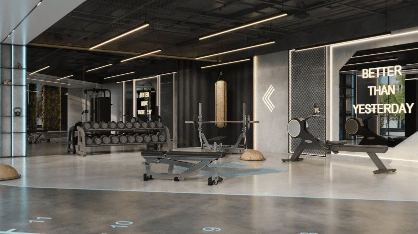 Un intérieur de salle de sport moderne avec divers équipements d'exercice, dont un support de poids, un sac de frappe et des machines cardio. Un texte de motivation sur le mur indique « Better Than Yesterday ». La pièce est bien éclairée avec des éléments de design industriel épurés.