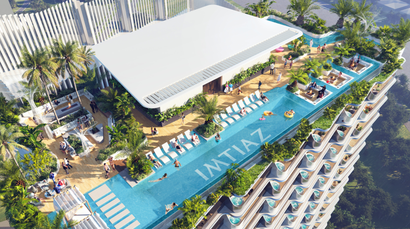 Vue aérienne d'une luxueuse piscine sur le toit d'un immeuble de grande hauteur à Dubaï, entourée de plantes tropicales, avec des gens bronzant et nageant.