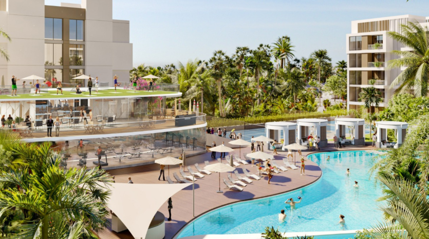 La lujosa piscina del complejo está rodeada de villas blancas y palmeras, con gente nadando y descansando bajo sombrillas y toldos.